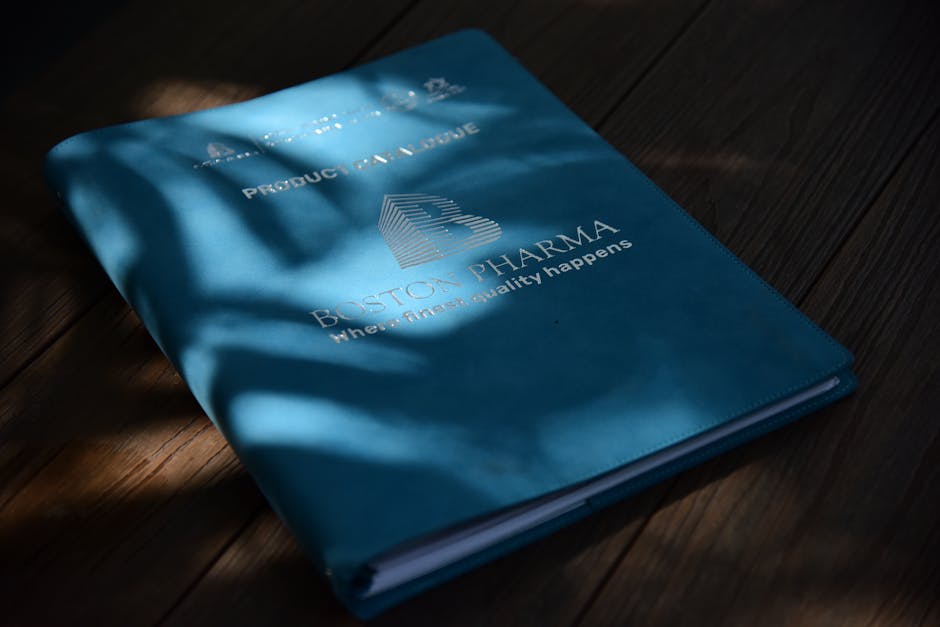 A blue folder with Boston Pharma branding in natural light on a wooden surface.